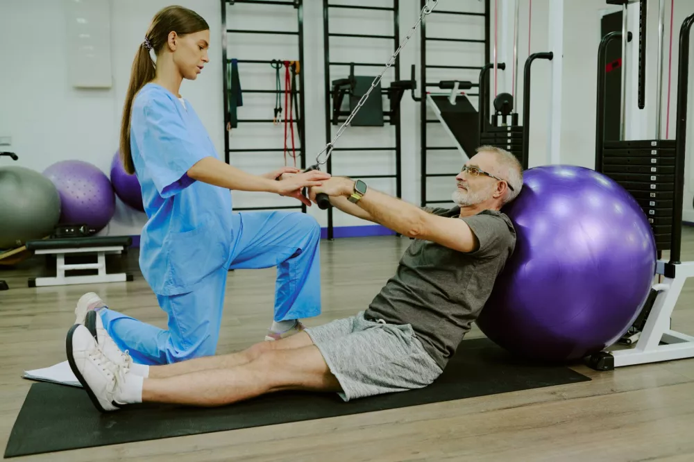 Fizjoterapeutka cwiczy z pacjentem podczas rehabilitacji